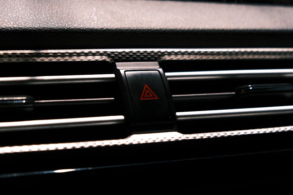 Red emergency hazard warning triangle button illuminated on a car dashboard panel