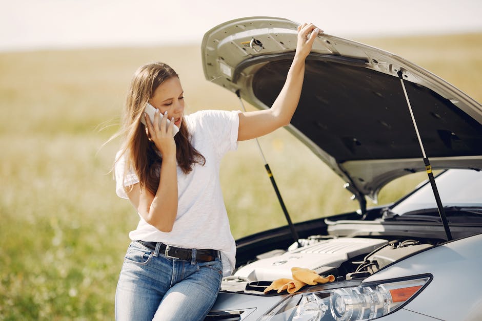 Woman standing next to her car with the hood open calling for emergency roadside help